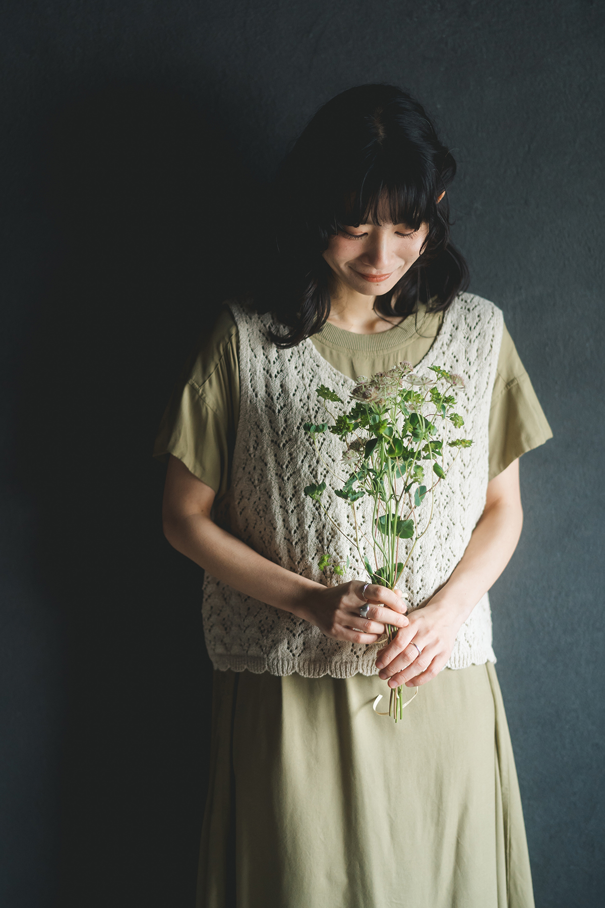 ベージュのケーブルニットを着た女性モデル写真