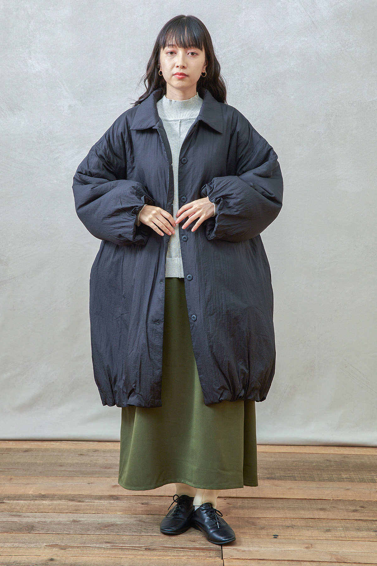 チャコールのアウターを着た女性