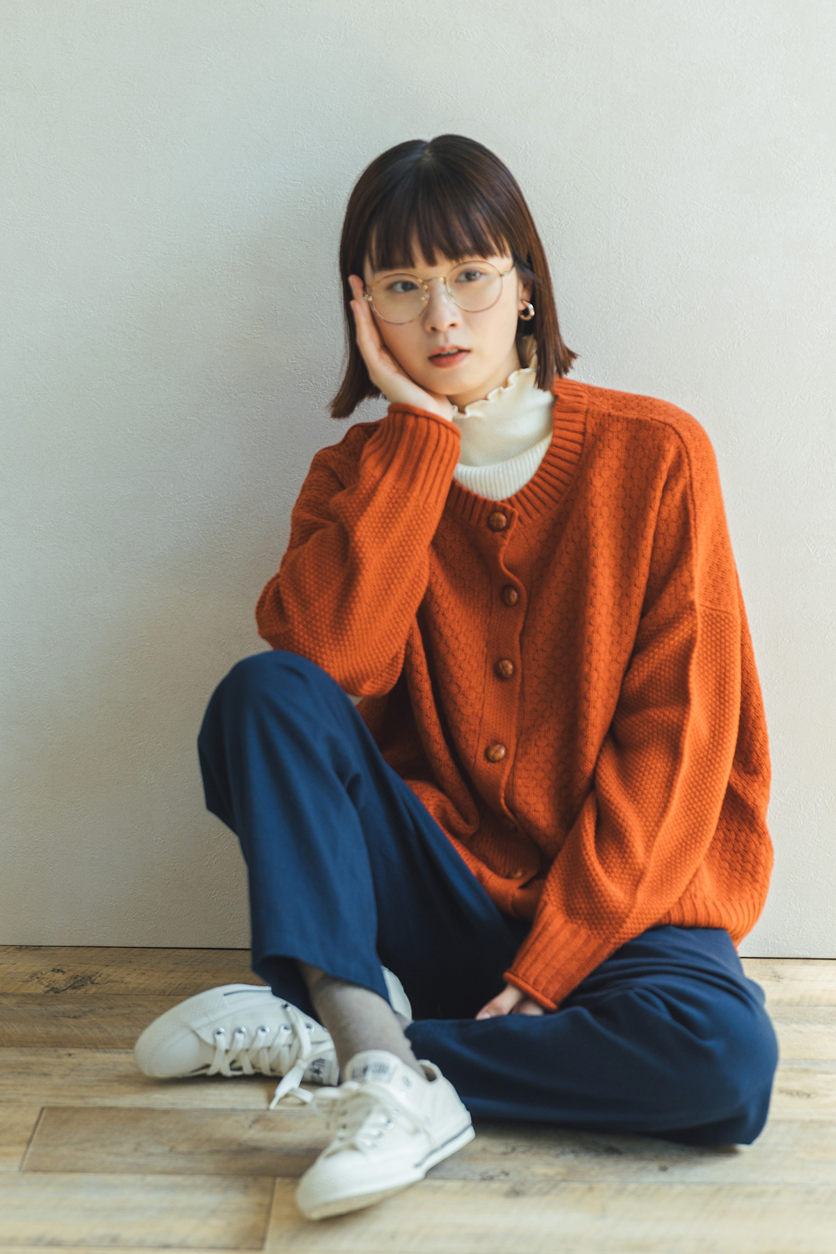 オレンジのニットを着た女性モデル写真