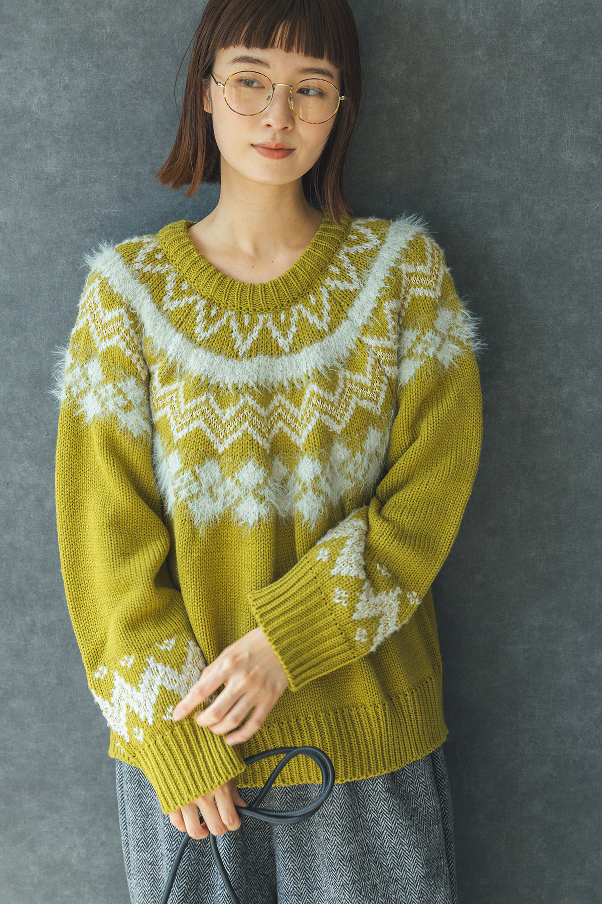 ライムイエローのニットを着た女性モデルの写真