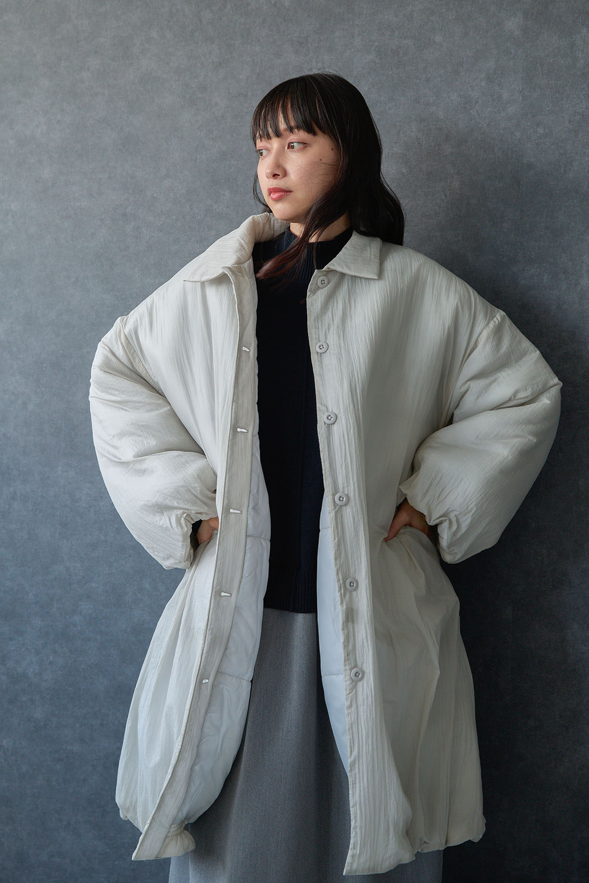 アイボリーのアウターを着た女性