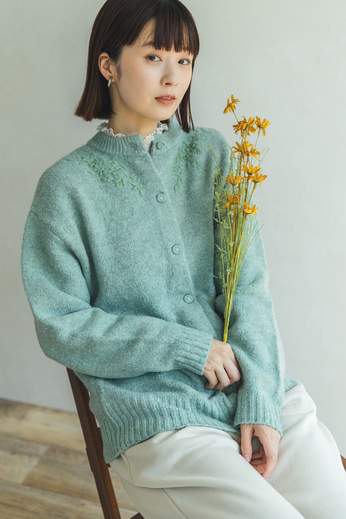 グリーンのニットを着た女性モデル写真