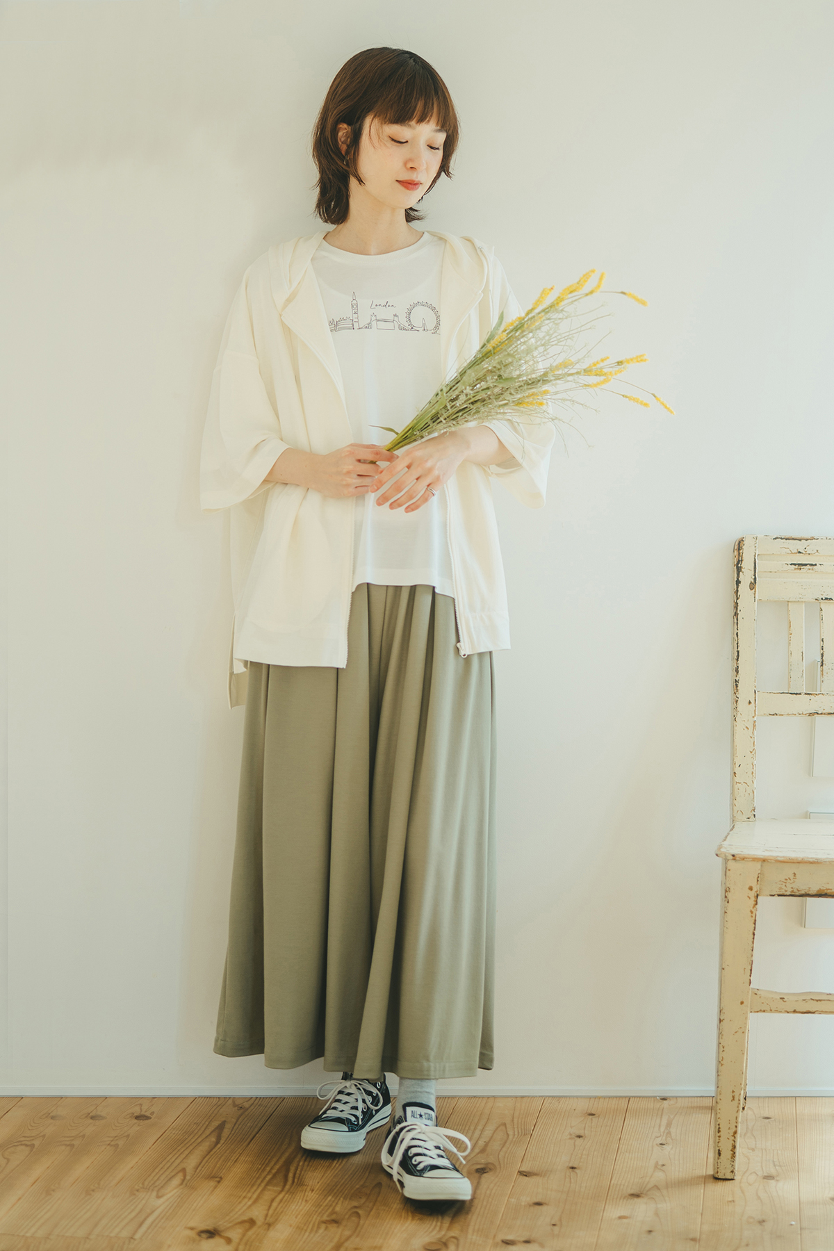 アイボリーのカーディガンのスカートを着た女性