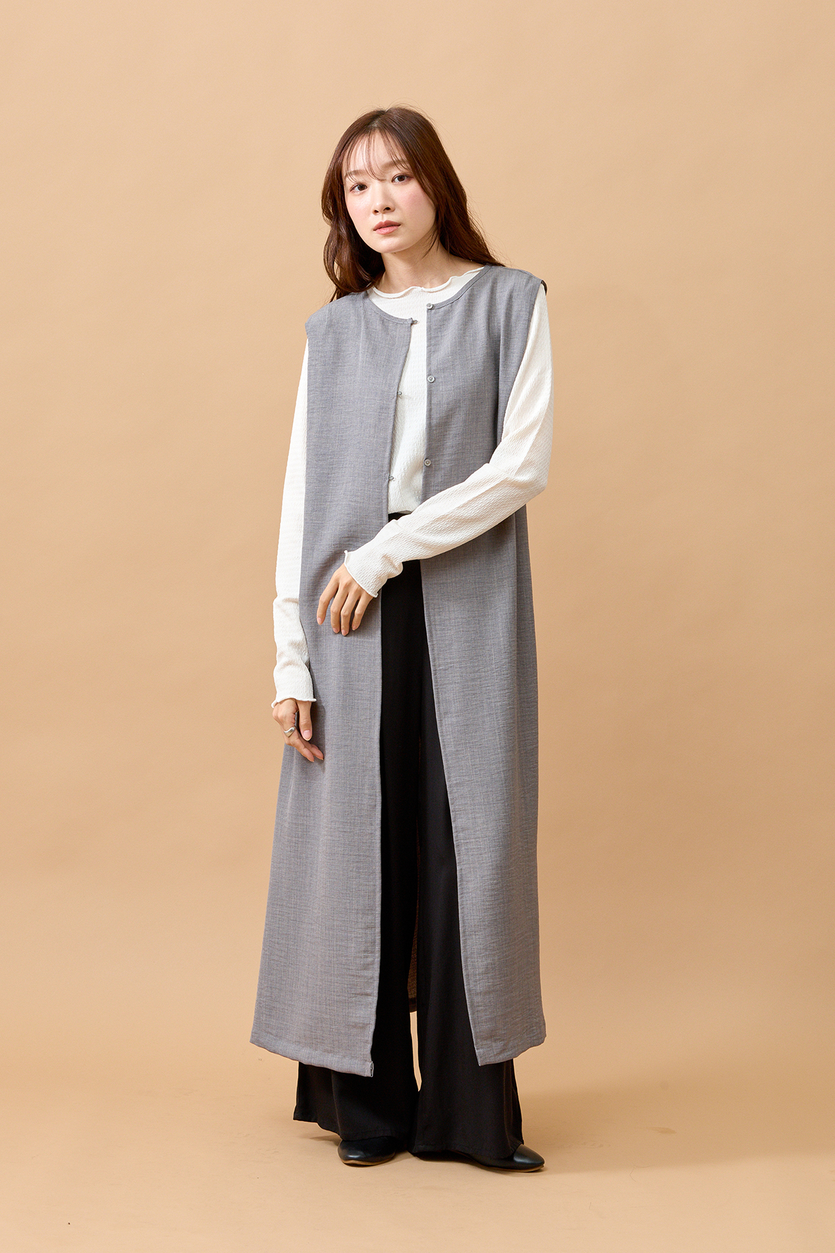 グレーのロングジレを着た女性