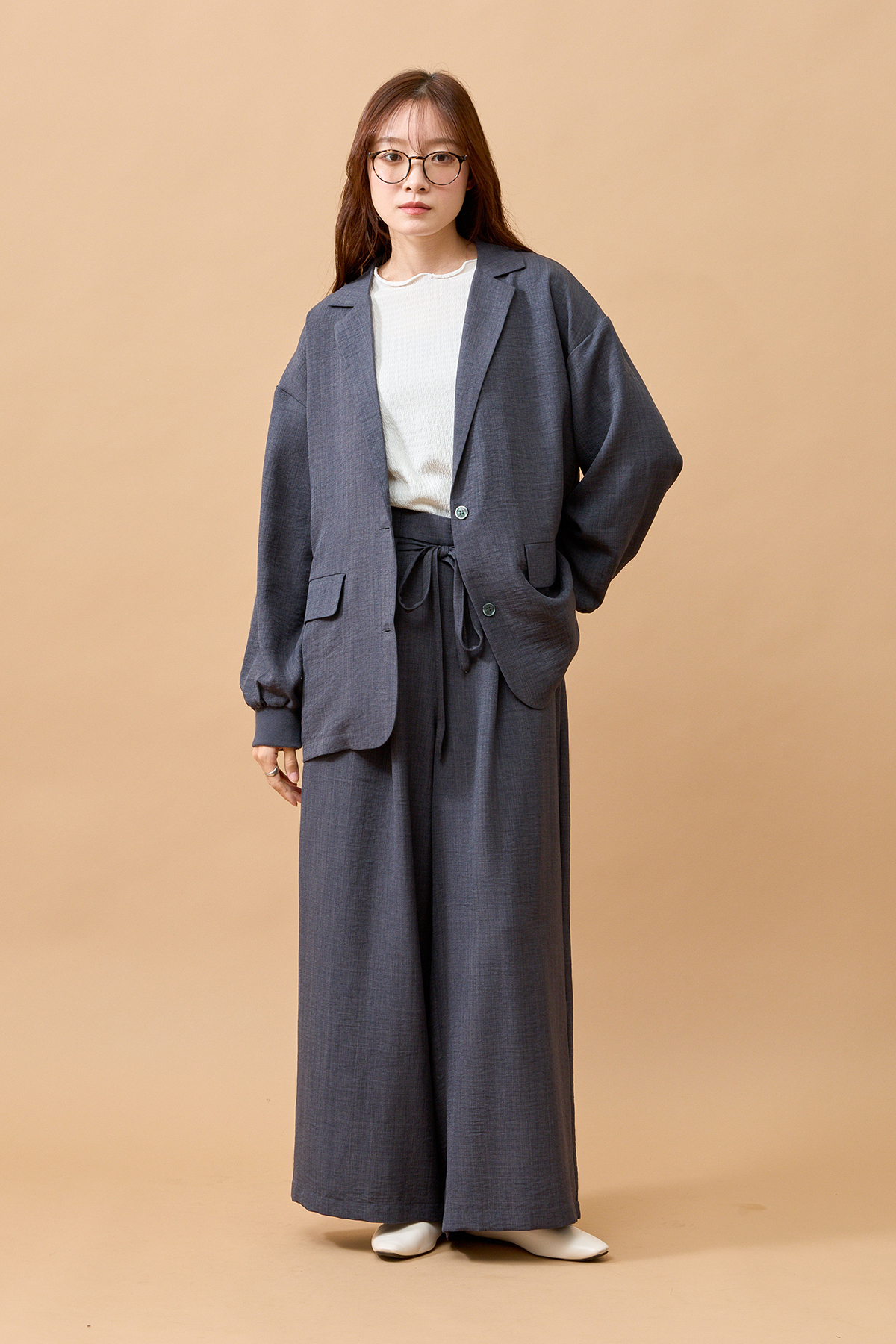 グレーのセットアップを着た女性